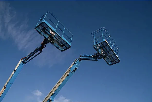 Cestos de plataformas articuladas azuis contra o céu